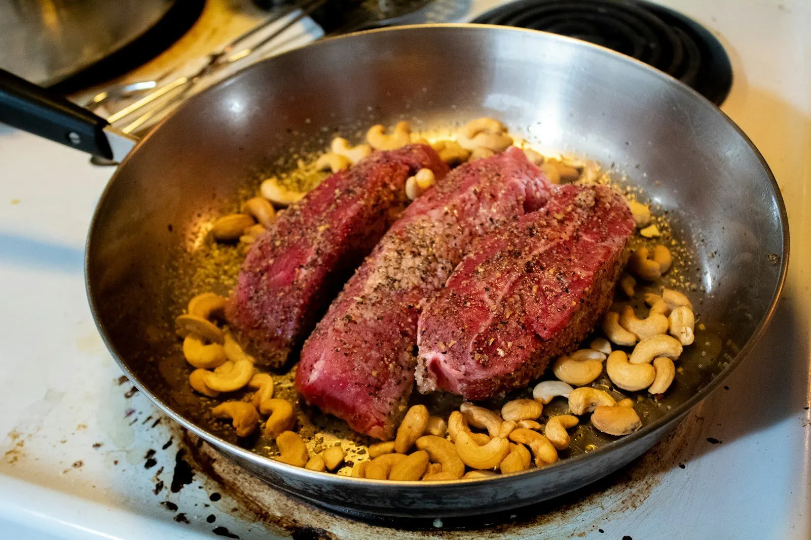 Corte de carne servido en la sartén con su guarnición