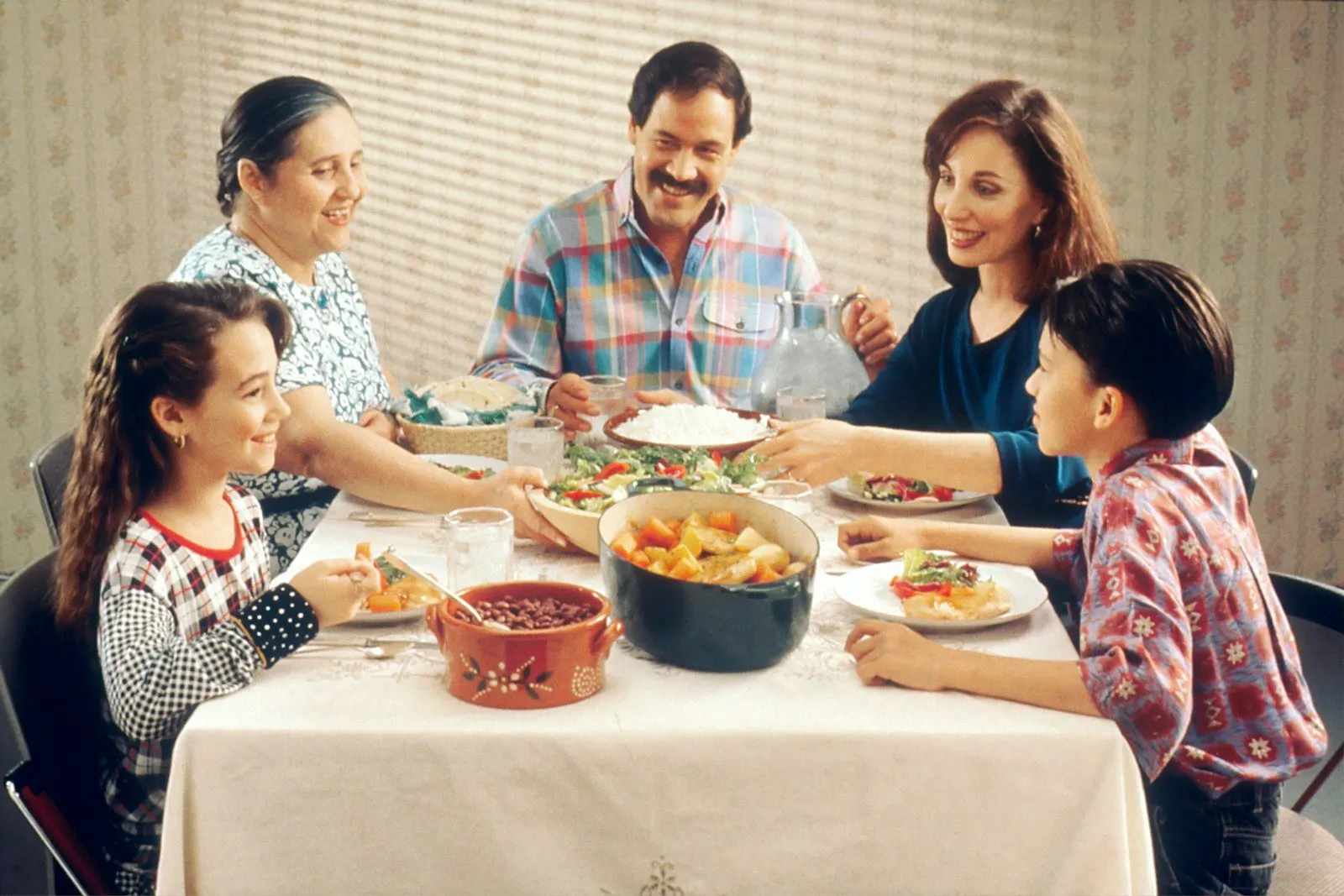 Familia compartiendo una comida alrededor de la mesa