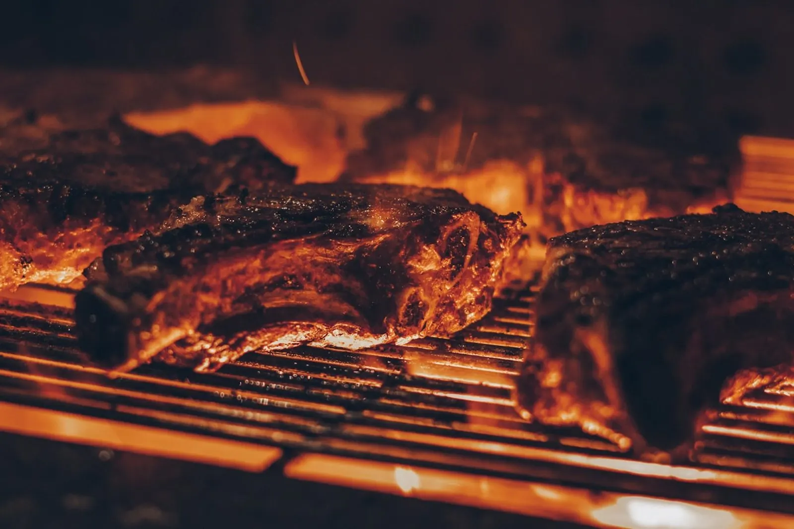 Carnes cocinándose sobre la parrilla al carbón